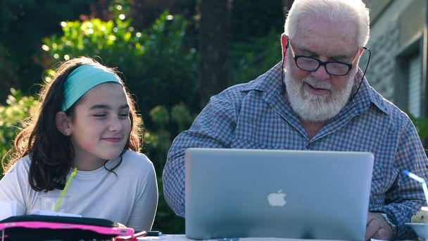 Starší muž vysvětluje, jak používat notebook své vnučce - Fotografie, Obrázek