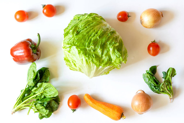 Органічні та біологічно свіжі овочі лежать в рамці на фоні білого столу. Концепція здорових натуральних стиглих вегетаріанських овочів. Інгредієнти для салату, Фермерський продукт
 . - Фото, зображення