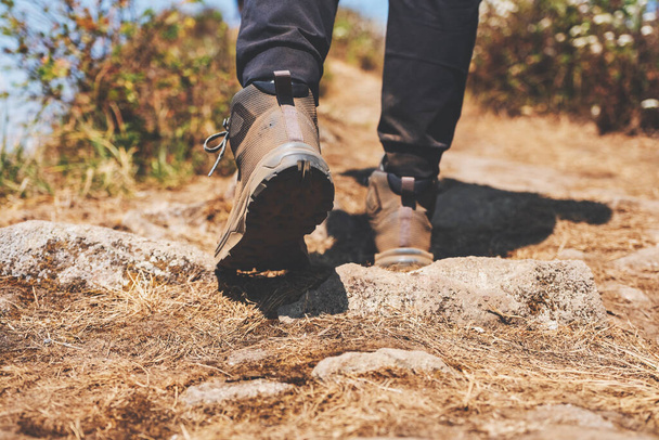 Closeup image of a woman hiking with trekking boots on the top of mountain - Фото, зображення