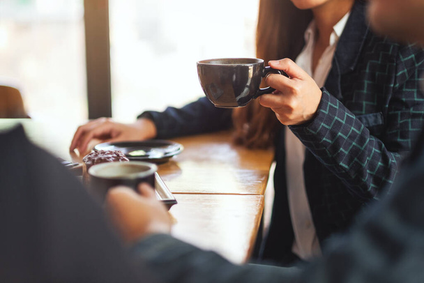 Крупным планом люди наслаждались разговорами и выпиванием кофе в кафе - Фото, изображение