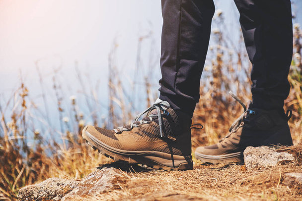 Image rapprochée d'une femme marchant avec des bottes de trekking au sommet de la montagne - Photo, image