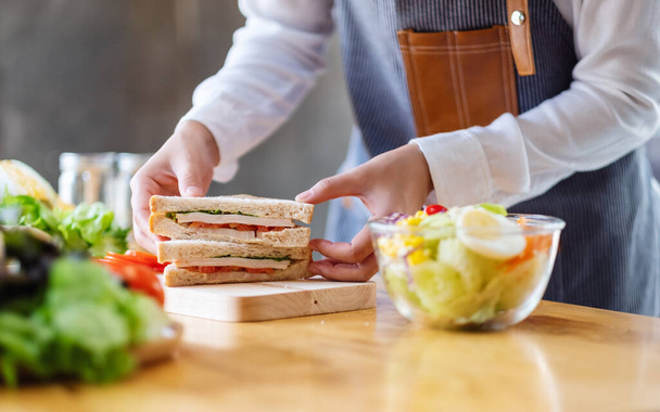 Крупним планом образ шеф-кухаря, який готує цілий пшеничний бутерброд та овочі салат на кухні
 - Фото, зображення