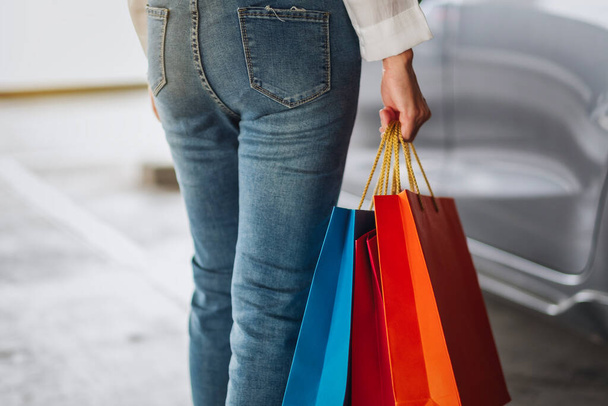 Imagen de una mujer sosteniendo bolsas de compras en el estacionamiento del centro comercial - Foto, Imagen