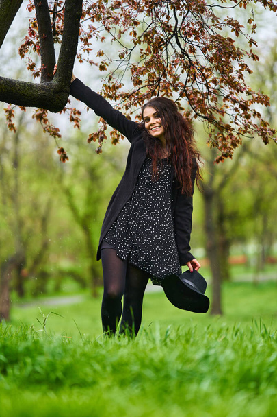 Young woman enjoying a spring rainy day in the park - Foto, afbeelding