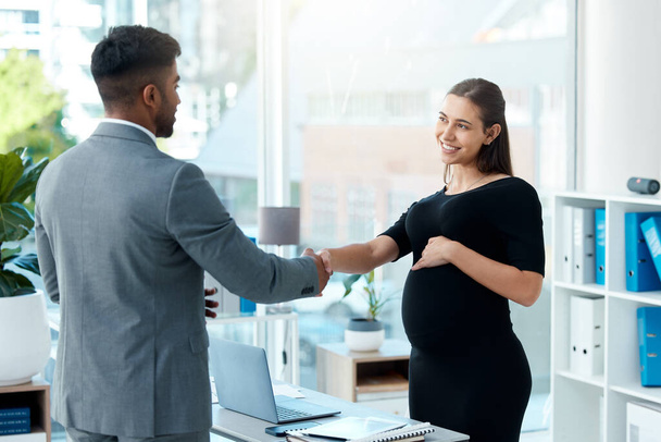Nothing will stop her from closing big sales. Shot of a pregnant businesswoman shaking hands with a businessman in an office. - Фото, зображення