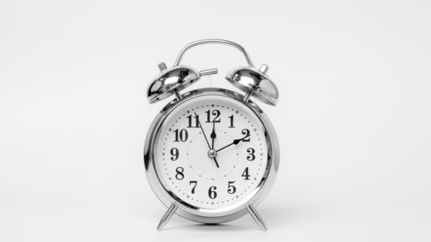 Time lapse of retro alarm clock running isolated on white background. Twelve o'clock on The New Years of the beautiful alarm clock face. Stop motion Animation of Alarm clock running. - Video