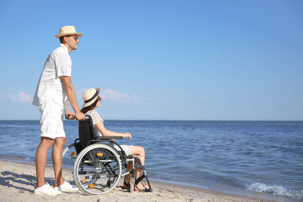 Mladý muž a jeho přítelkyně s tělesným postižením na moři resort - Fotografie, Obrázek