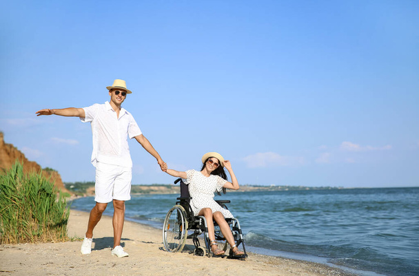 Šťastná žena s tělesným postižením a její přítel na moři resort - Fotografie, Obrázek