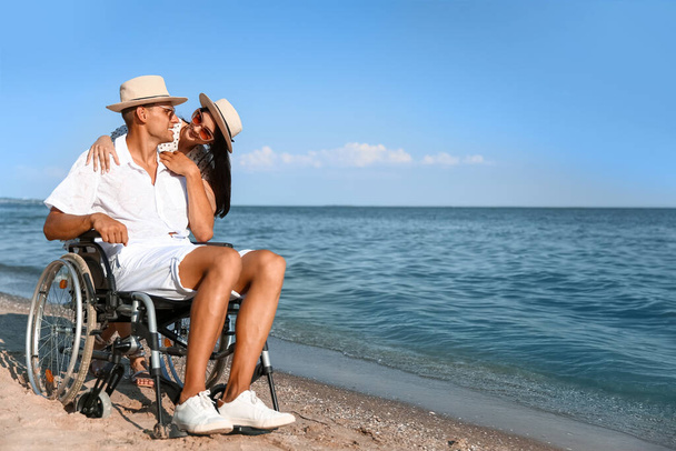 Young man with physical disability and his girlfriend at sea resort - Foto, Imagen