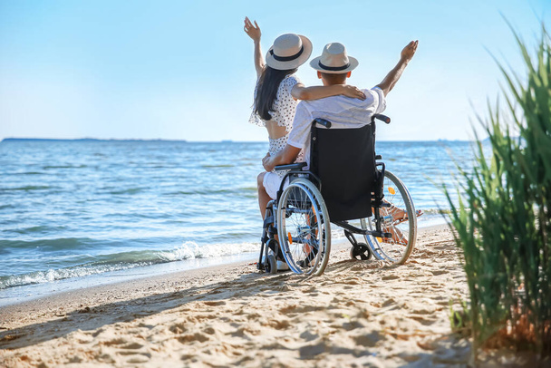 Homme heureux avec un handicap physique et sa petite amie en station balnéaire - Photo, image