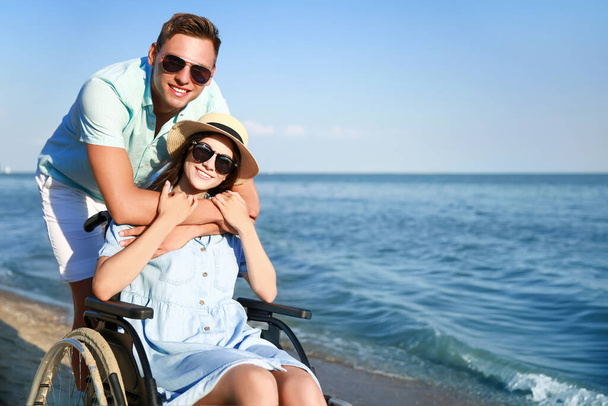 Щаслива жінка з фізичною вадою і її хлопець на морському курорті
 - Фото, зображення