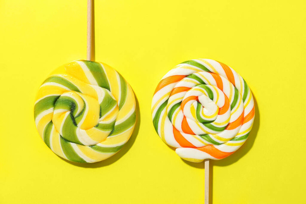 Sweet lollipops on yellow background, closeup - Foto, Imagen