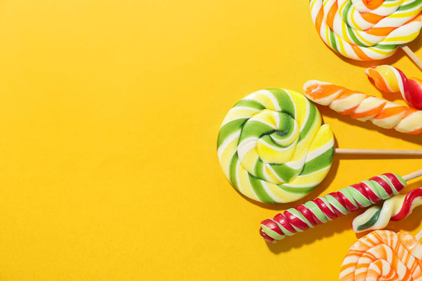 Many sweet lollipops on color background, closeup - Фото, изображение