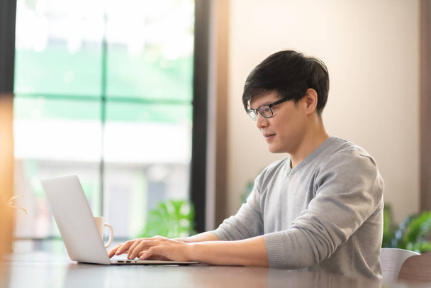 Young Asian man using laptop, Male Freelancer working. - Foto, afbeelding