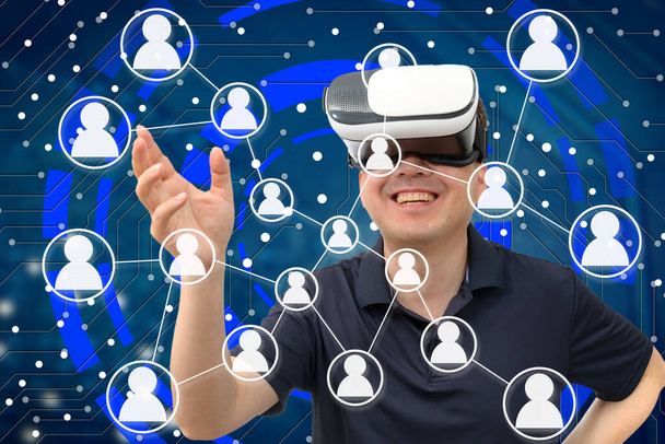 A man wearing a VR headset. Metaverse, cyber virtual society concept - Фото, изображение