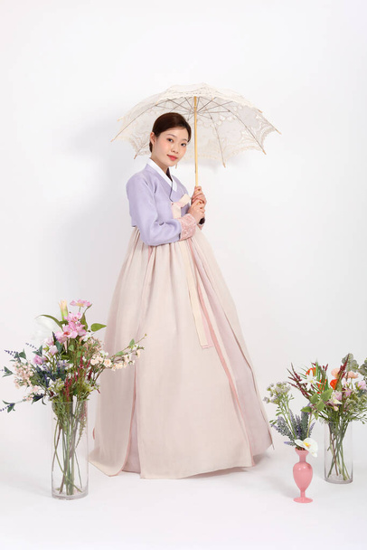 spring beauty concept, beautiful korean woman wearing hanbok with umbrella - Foto, Imagen