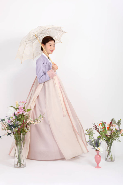 spring beauty concept, beautiful korean woman wearing hanbok with umbrella - Фото, изображение
