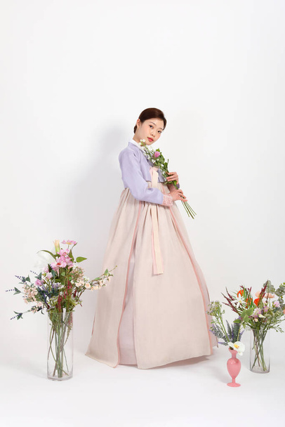 spring beauty concept, beautiful korean woman wearing hanbok with flowers - Foto, imagen