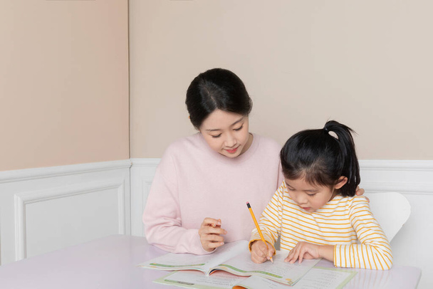 Asian Korean daughter studying with mom - Photo, image
