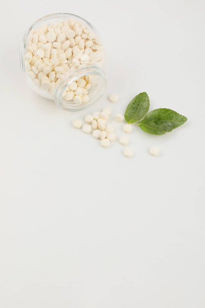 pills and plants, white background, medical creative concept photo - Foto, afbeelding