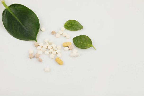 plants and pills, white background, medical creative concept photo - Foto, afbeelding