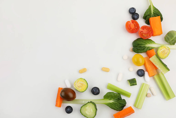 vegetables and pills, white background, medical creative concept photo - Foto, Imagem