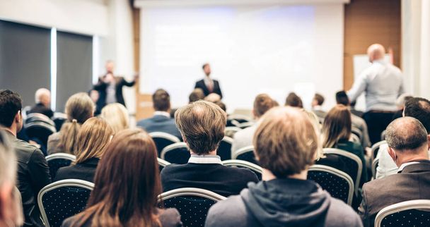 I have a question. Group of business people sitting in conference hall. Businessman raising his arm. Conference and Presentation. Business and Entrepreneurship - Photo, Image