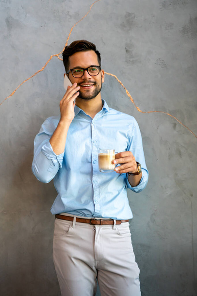 Portrait of successful business man talking on smartphone in coffee break in corporate office - Foto, immagini
