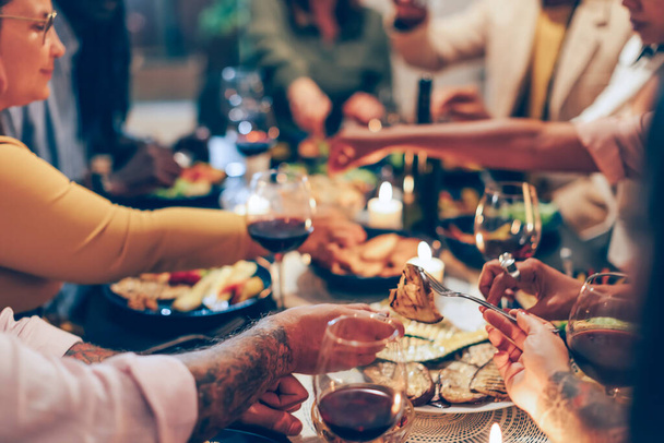 Familie am Tisch - vegane Freunde beim gemeinsamen Abendessen - Fucus im Vordergrund - Foto, Bild