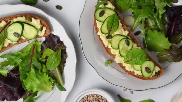 Healthy food. Sandwiches with goat cheese and greenery, ready to eat - Footage, Video