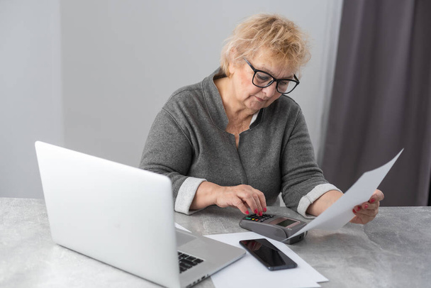 Συνταξιούχος γυναίκα που υπολογίζει τους λογαριασμούς της - Φωτογραφία, εικόνα
