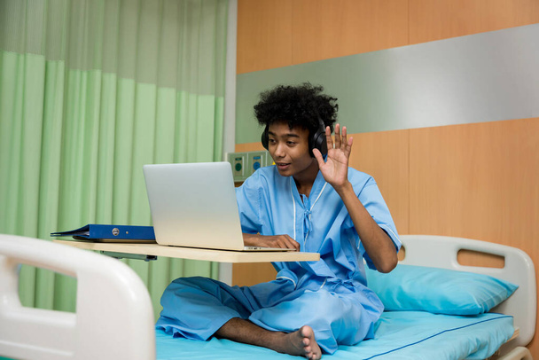 African American patient man talking to web camera having video conference calling in virtual chat. patient man video chat on bed at hospital. - Foto, afbeelding