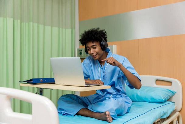 African American patient man talking to web camera having video conference calling in virtual chat. patient man video chat on bed at hospital. - Foto, immagini
