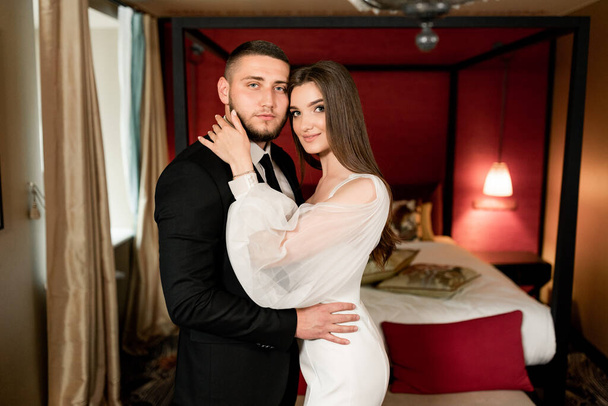 beautiful bride and groom in a hotel room interior - Фото, изображение