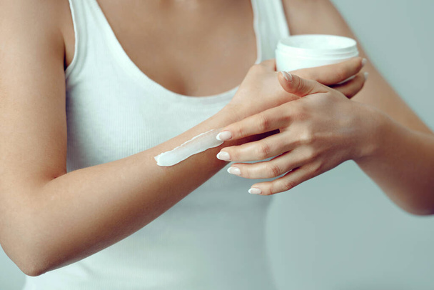 Beautiful woman hands with cream. Closeup woman applying protective cream on hands. - Photo, Image