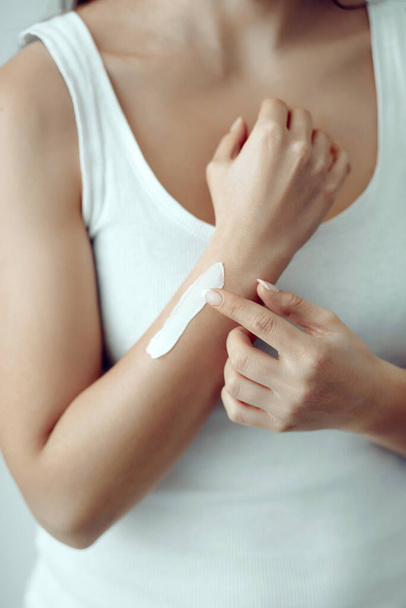 Woman hands applying moisturizing cream to her skin.   Soft skin, skincare concept. Hand skin care. - Zdjęcie, obraz