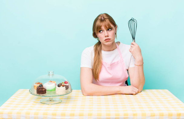 red head pretty woman feeling sad, upset or angry and looking to the side. home made cakes concept - 写真・画像