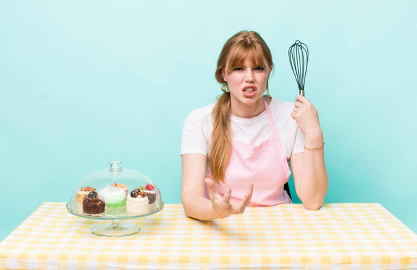 red head pretty woman looking angry, annoyed and frustrated. home made cakes concept - 写真・画像