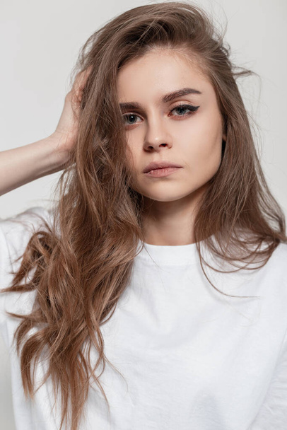Portrait of beautiful woman with pretty face and hairstyle in white t-shirt look at the camera in studio. Fashion girl in casual clothes - Fotoğraf, Görsel