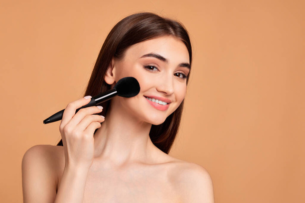 model applying powder with make-up brush - Fotoğraf, Görsel
