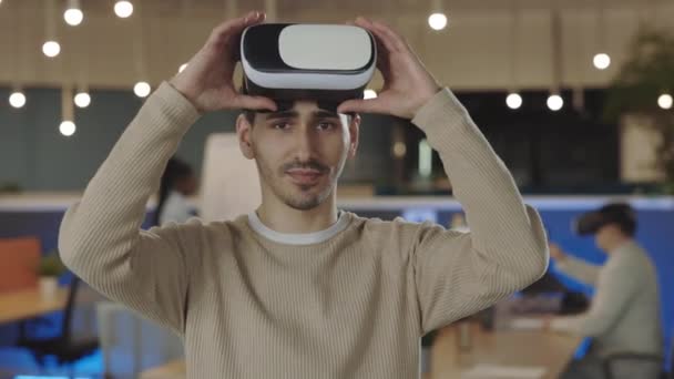 Pracownik biurowy ubrany w słuchawki VR, koncepcja rzeczywistości wirtualnej. Portret kaukaski programista stojący w biurze testujący nowe technologie. To, biznes i koncepcja nowych technologii. - Materiał filmowy, wideo