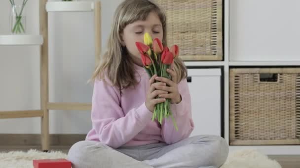 Kaukasisches Mädchen mit Geschenk und Tulpenstrauß - Filmmaterial, Video