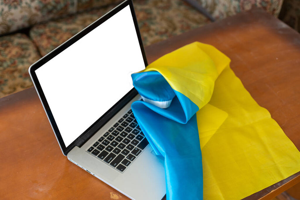 laptop pusty ekran na tle flagi Ukrainy. przestrzeń kopiowania - Zdjęcie, obraz