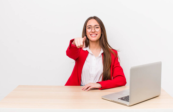 hispanic pretty woman pointing at camera choosing you.  business and desk concept - Foto, afbeelding