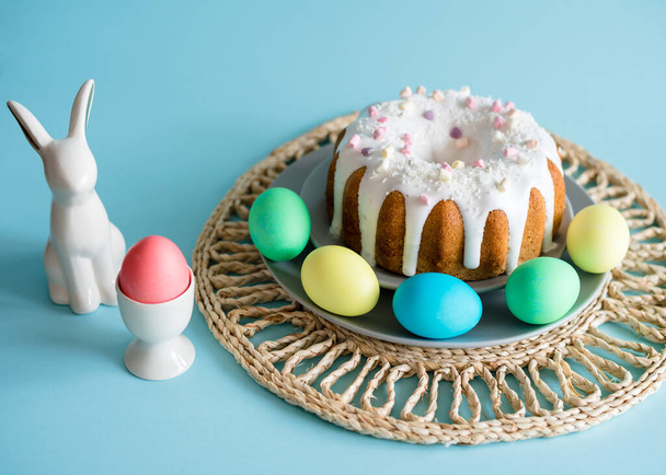 Lezzetli Paskalya pastaları ve yumurtalar, mavi arka planda Paskalya tavşanı. Asgari konsept.  - Fotoğraf, Görsel