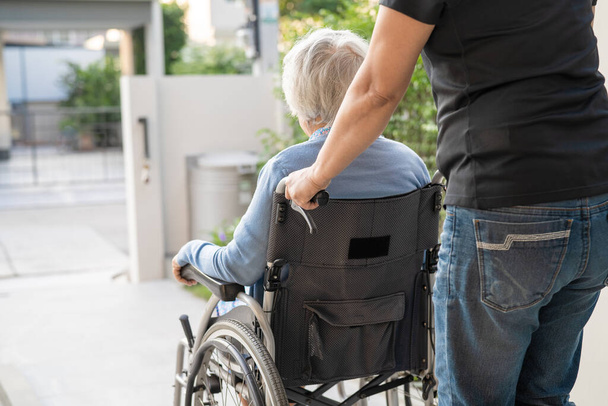 介護者のヘルプとケアアジアの高齢女性高齢者の女性患者は、病院病棟で車椅子に座って、健康的な強い医療の概念 - 写真・画像