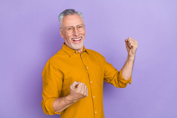 Photo of funny old grey hairdo man yell wear yellow shirt isolated on purple color background - Foto, Imagem