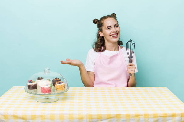 young pretty woman  smiling cheerfully, feeling happy and showing a concept. home made cakes concept - 写真・画像