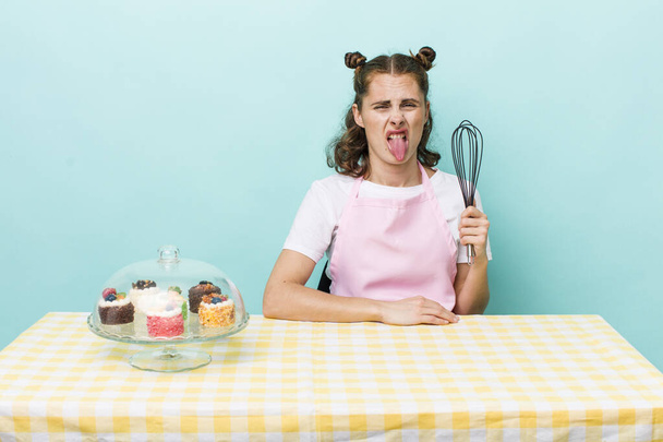 young pretty woman  feeling disgusted and irritated and tongue out. home made cakes concept - Fotoğraf, Görsel