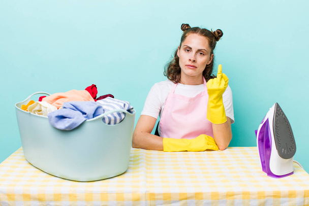 young pretty woman  feeling angry, annoyed, rebellious and aggressive. house work concept - 写真・画像